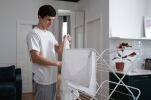 Homme faisant sécher son linge chez lui