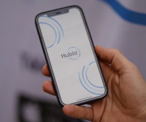 Main tenant un smartphone sur l'application Hublo