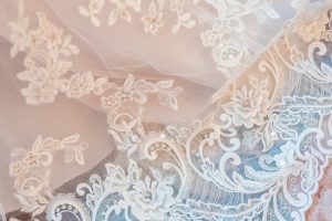 Vertical shot of a white bridal lace fabric robe en dentelle blanche